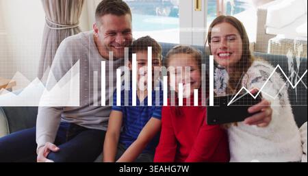 Taking family of four posing on sofa at home, holding smartphone, sweaters, overlay charts Stock Photo
