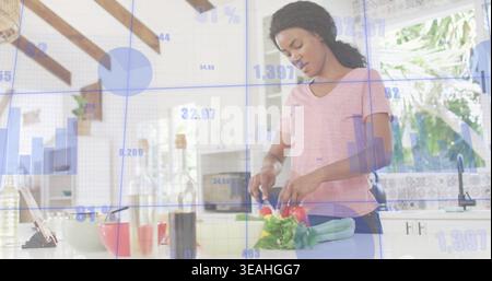 Slicing woman in pink tee preparing tomatoes on cutting board in kitchen with tablet, blue overlay Stock Photo