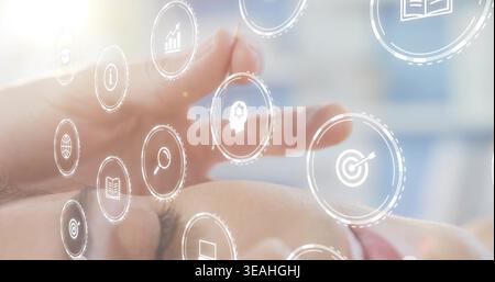 Pointing adult female touching see-through round digital icons in office, finger selecting target Stock Photo