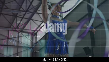 Performing teenage gymnast in blue leotard twirling hoops and ribbon in gym, with graphs Stock Photo