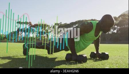 Holding hex dumbbells, adult man doing push-ups on grass field with data overlay wearing neon tank Stock Photo