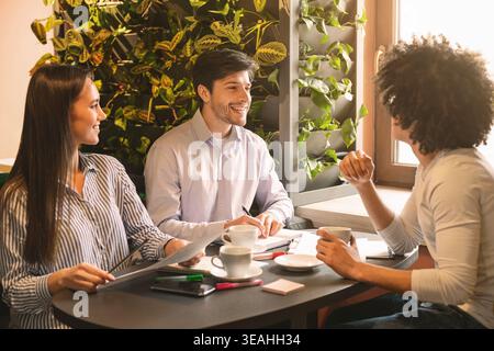 Group of young businesspeople having briefing in cafe Stock Photo