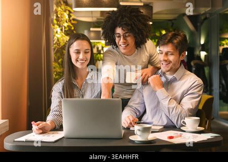 Team Members Collaborate in a Modern Workspace With Laptops and Coffee in Bright Atmosphere Stock Photo