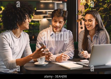 Young man sharing creative ideas with colleagues Stock Photo