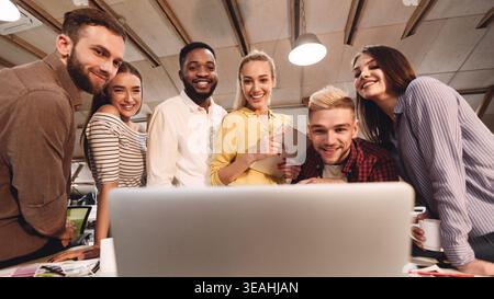 Software developers discussing new project, looking at laptop Stock Photo
