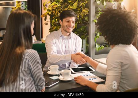 Handshake of businessmen during lunch break in cafe Stock Photo