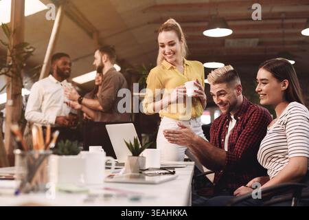Colleagues working on project, using laptop at workplace Stock Photo