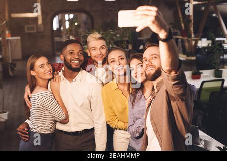 Happy international creative business team taking selfie Stock Photo
