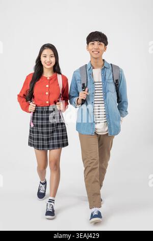 Two students walking together, smiling, on a college campus. Stock Photo