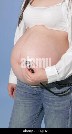 Close up of stethoscope on a pregnant woman stomach Stock Photo