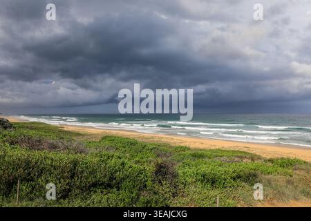Dark stormy clouds forming over North Beach in Mylestom, New South Wales, Australia. Dramatic coastal scene showing approaching weather over ocean. Stock Photo