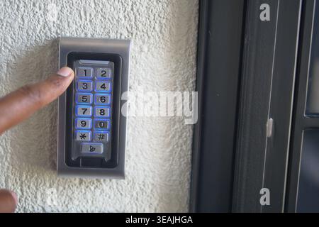 Entering a code on a keypad at a building entrance Stock Photo