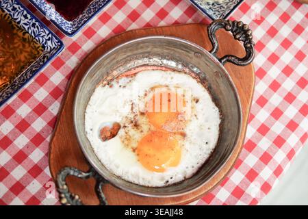 Enjoying eggs in a dish on a checkered table Stock Photo