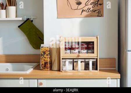 A modern kitchen with various food ingredients and cooking tools on a wooden counter. Stock Photo