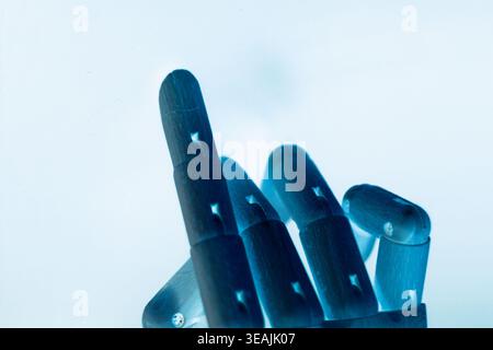 Close-up of a neon blue robotic hand pointing with the index finger, isolated on a clean white background with copy space. Futuristic concept of artif Stock Photo