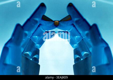 Close-up of two robotic hands touching fingertips in a creative composition, isolated on a clean white background with copy space. Futuristic concept Stock Photo