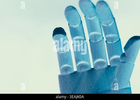 Close-up of a neon blue robotic hand with open palm isolated on a clean white background with copy space. Futuristic concept symbolizing artificial in Stock Photo