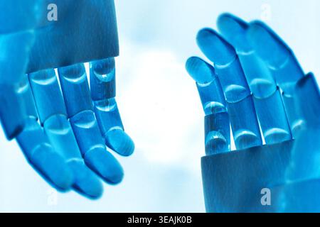 Close-up of two neon blue robotic hands shown from a side perspective, positioned left and right with open palms, isolated on a clean white background Stock Photo