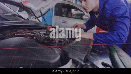 Inspecting mechanic in blue coverall leaning over open hood in garage checking wiring, copy space Stock Photo