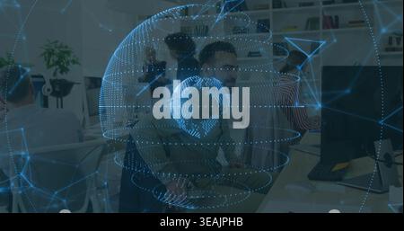 Projecting blue holographic globe over open-plan office, team leaning toward monitor, businesswear Stock Photo