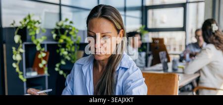 Businesswoman analyzing timeline amidst team collaboration Stock Photo