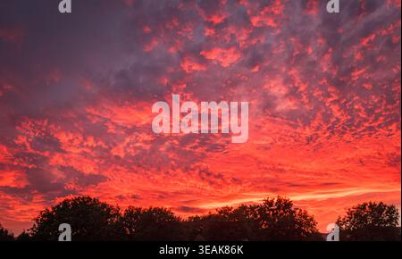 Fiery red clouds painting dramatic sunset sky Stock Photo