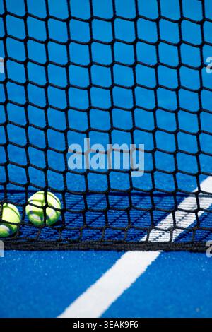 Vertical view through a black net showing sports balls on a blue surface The Concept of leisure and hobby Stock Photo