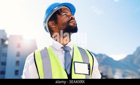 Black man, architect and thinking with helmet in city for building, construction or security. Thoughtful, male person or civil engineer with ambition Stock Photo