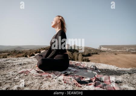 Woman Meditating on a Mountaintop Stock Photo