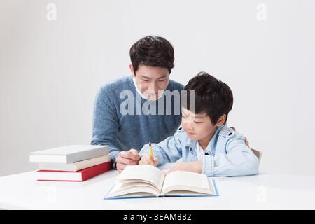 a father helping his son with homework Stock Photo
