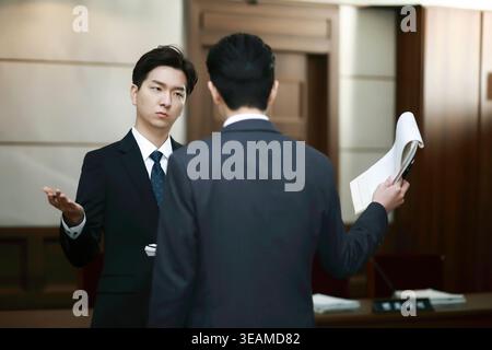 Two business colleagues discuss a document in a corporate office. Stock Photo