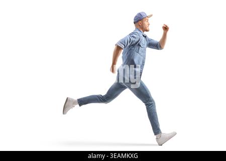 Young man in denim outfit running fast isolated on white background Stock Photo