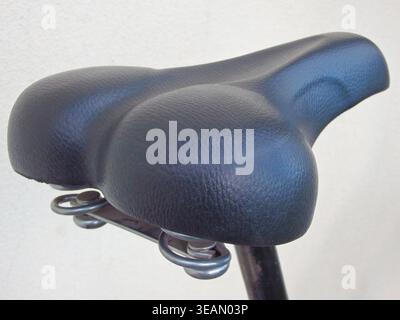Black leather bicycle seat close-up. Bicycle seat on a white background. Cropped Image Of Bicycle On Street Stock Photo