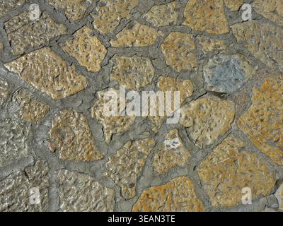 Natural stone pavement in Palma with irregular texture and organic pattern. Top view in direct sunlight. Copy space. Stock Photo