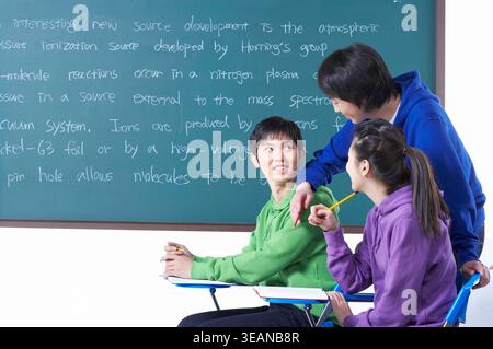 A group of students are engaged in a lively discussion in a classroom. Stock Photo