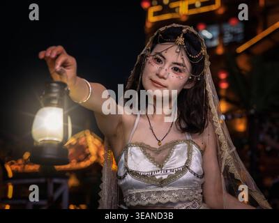 Chinese woman dressed in wedding clothing holding a lamp at night, Chongqing, China Stock Photo