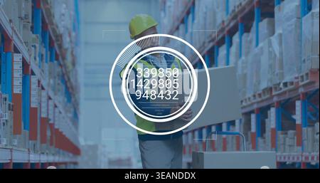 Carrying worker in yellow hard hat, lime vest holding box in warehouse aisle with HUD numbers. Inventory, logistics, fulfillment, storage, pallets, ba Stock Photo
