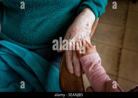 Two generations, close up shot of grandmother with small granddaughter hand, concept of time and life cycle and family Stock Photo