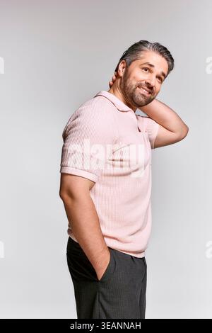 Elegant man exudes charm and style while posing with a relaxed demeanor in a contemporary backdrop. Stock Photo