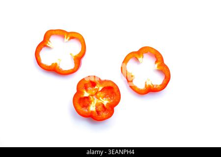 Three fresh red bell pepper slices isolated on white background. Top view of sliced organic capsicum pieces, healthy cooking ingredient. Stock Photo