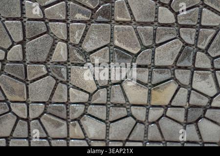Small stone mosaic pattern forming organic texture. Natural decorative surface.  Stock Photo