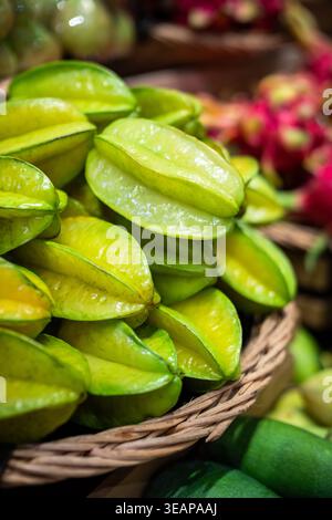Basket full of fresh ripe tropical carambola fruit selling at local supermarket in Thailand. Stock Photo