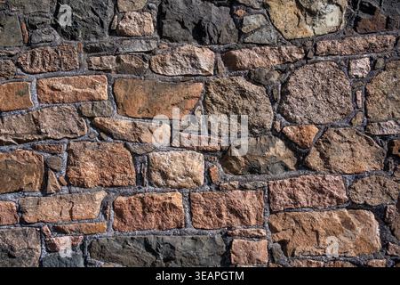 Rough granite stone wall for use as a background texture Stock Photo