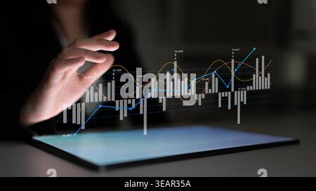 Business Professional Using Touchscreen Device to Analyze Financial Data Displaying Digital Graphs and Charts with Dynamic Trends and Metrics Ledger. Stock Photo