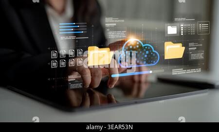 A professional using a tablet to interact with digital cloud technology, showcasing file organization and data management concepts in a modern Stock Photo