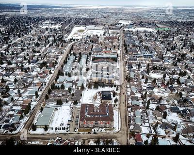 Aerial view of Lawson Heights neighborhood in Saskatoon. Snow blankets streets and rooftops. Houses line a grid pattern. Trees dot the snowy landscape Stock Photo