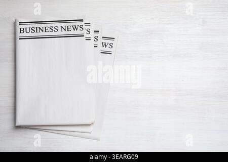 Folded newspapers on white wooden background, top view Stock Photo