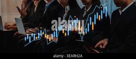 A group of business professionals analyzes financial data during a conference. The image features dynamic graphs and charts, showcasing market trends Stock Photo