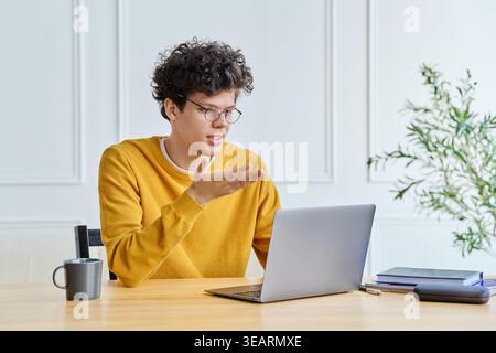 Young man freelancer or student using laptop for video call, at home office Stock Photo