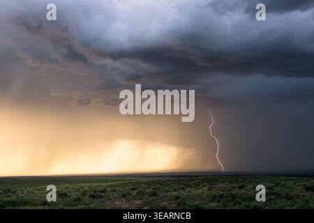 Stormy sky with lightning over a field at sunset near Sedgwick, Colorado Stock Photo